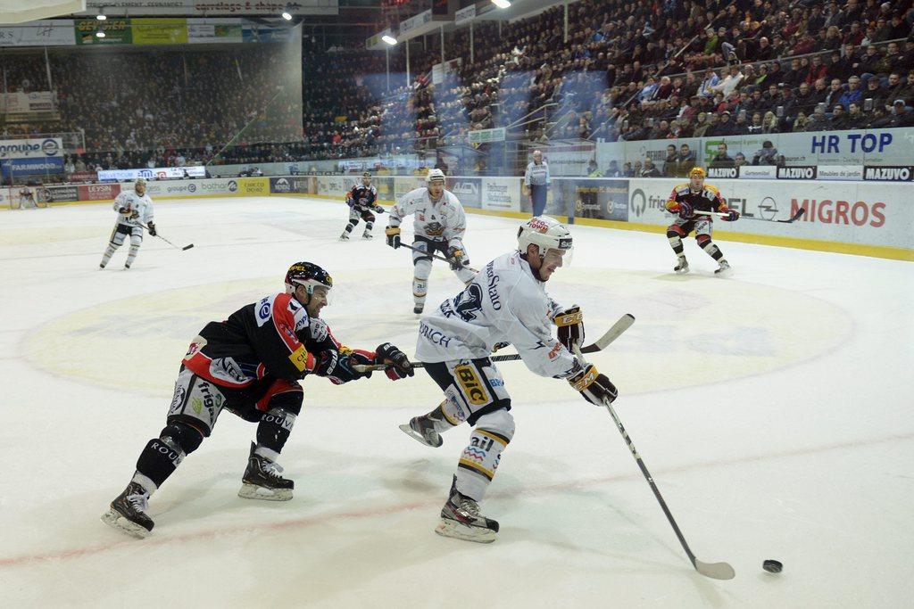 Benjamin Plüss, au duel avec Stefan Ulmer, et Fribourg cèdent leur 1ère place à Berne en raison des confrontations directes favorables aux Ours. [KEYSTONE - Alessandro Della Valle]