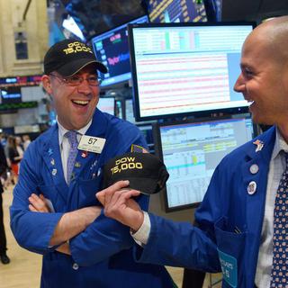 Les employés de Wall Street avaient le sourire vendredi au moment où le Dow Jones a franchi la barre historique des 15'000 points. [EPA/Justin Lane]