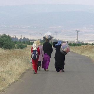 Femmes syriennes quittant Homs, au centre de la Syrie, après des combats, le 23 juin 2012. [Shaam News Network / AFP]