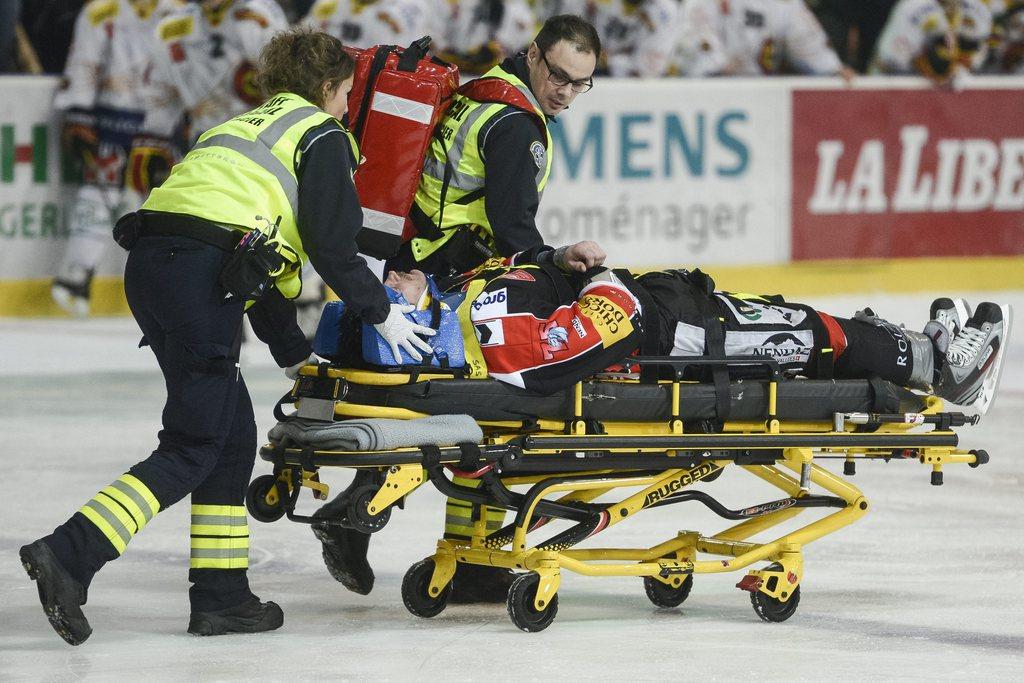 Fribourg's defenseman Shawn Heins receives medical care, during the third leg of the Playoff-finals game of the National League A Swiss Championship between the HC Fribourg-Gotteron and the SC Bern at the ice stadium BCF-Arena in Fribourg, Switzerland, Tuesday, April 9, 2013. (KEYSTONE/Jean-Christophe Bott) [KEYSTONE - Jean-Christophe Bott]