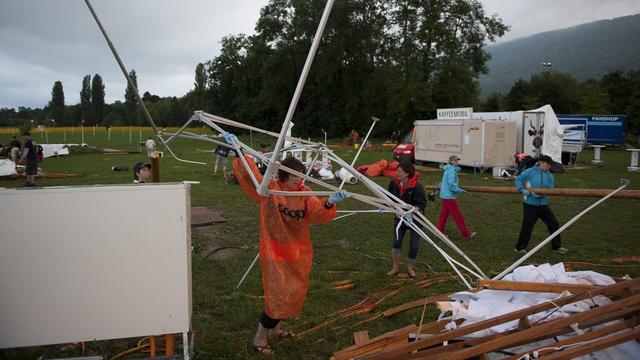 Les bénévoles de la Fête fédérale de gym au travail après la tempête. [KEYSTONE - Gian Ehrenzeller]