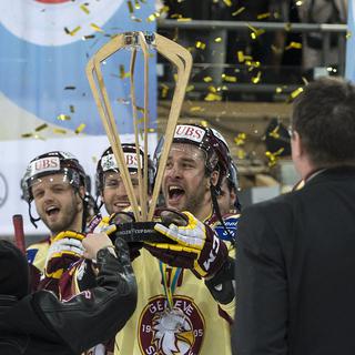 Le capitaine de Genève-Servette Goran Bezina soulève le trophée de la Coupe Spengler. [Peter Schneider]