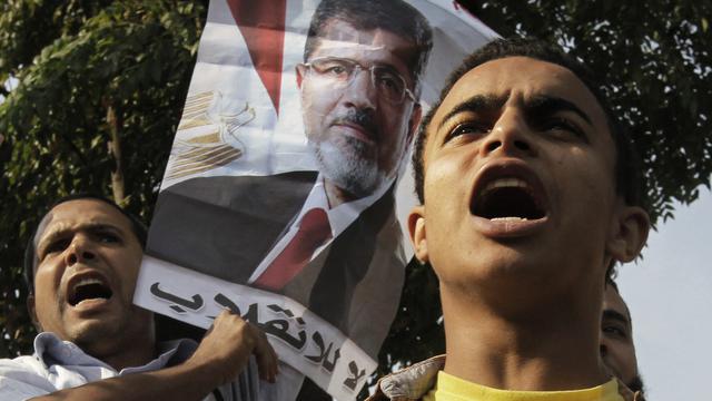 Les supporters de l'ex-président égyptien déchu Mohammed Morsi devant le tribunal où son procès a été ajourné lundi 4 novembre. [AP/Keystone - Amr Nabil]