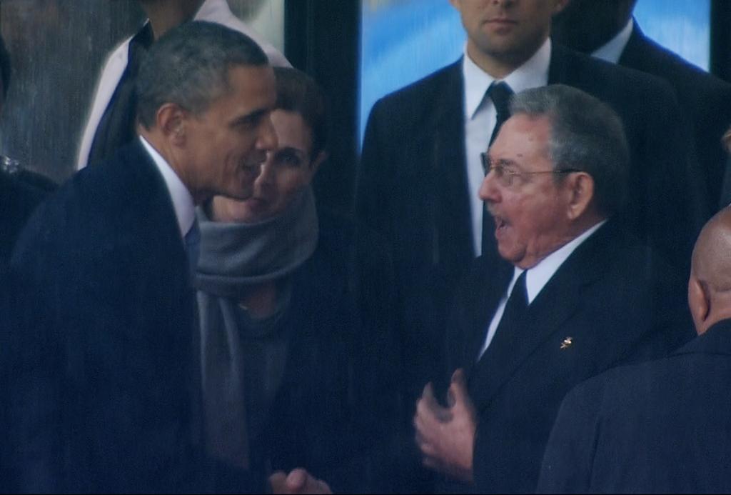 La poignée de main historique entre Barack Obama et Raul Castro saisie par une caméra de télévision. [AP Photo/SABC Pool]