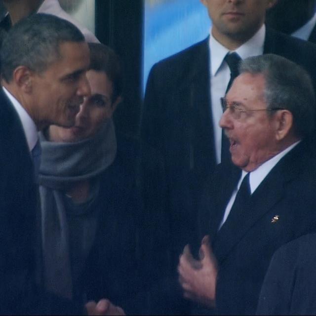 La poignée de main historique entre Barack Obama et Raul Castro saisie par une caméra de télévision. [AP Photo/SABC Pool]