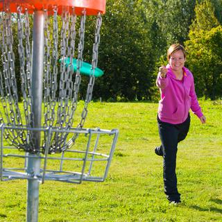 Le but du disc-golf est d'arriver à lancer son freesbee dans le panier. [Jari Hindström]