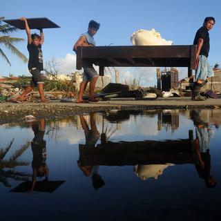 Les Philippins essayent de récupérer du matériel et de la nourriture. [Noël Celis]
