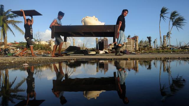 Les Philippins essayent de récupérer du matériel et de la nourriture. [Noël Celis]