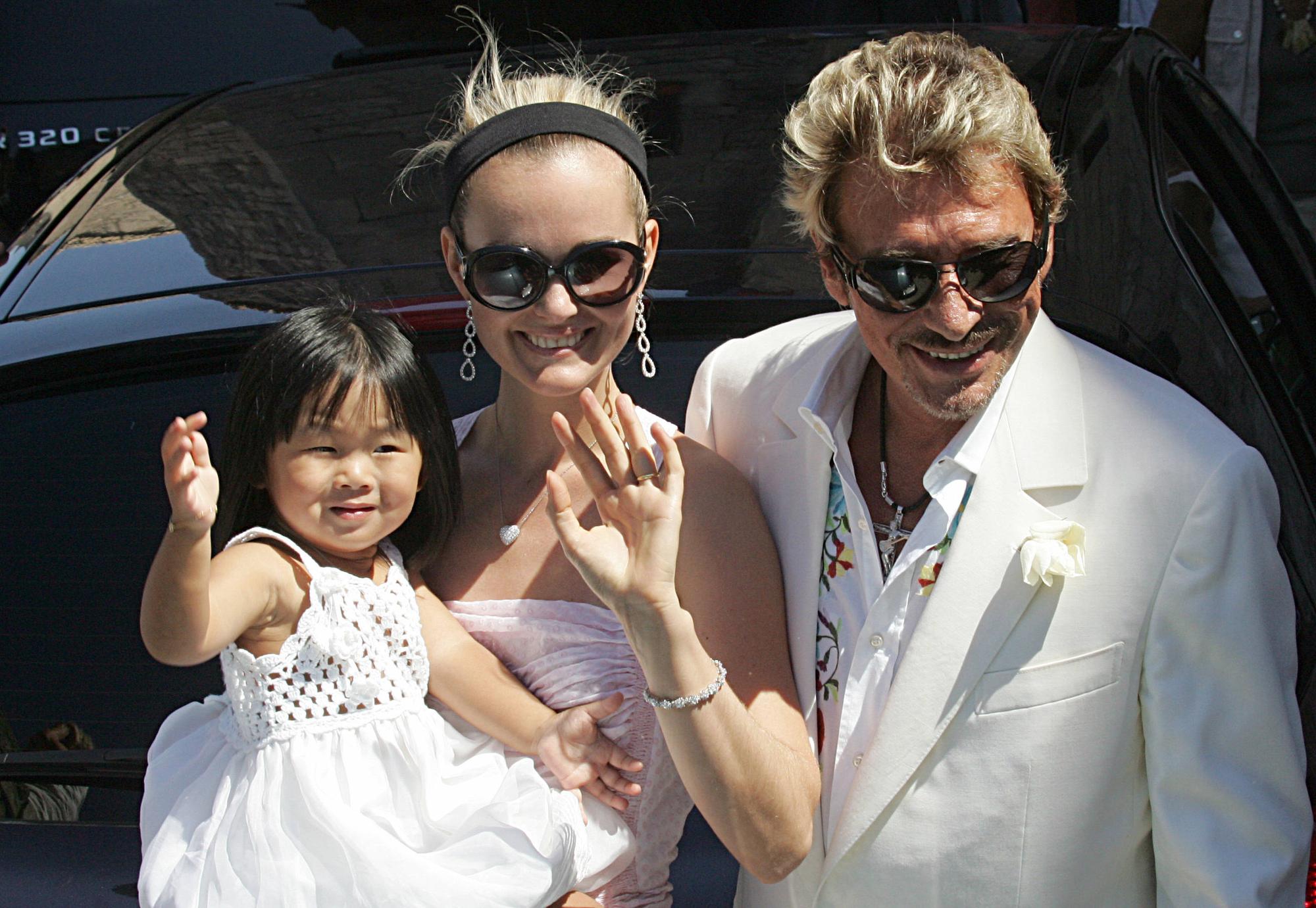 Juillet 2009: Laeticia et Johnny en compagnie de Jade première des deux petites filles adoptées par le couple. [BORIS HORVAT]