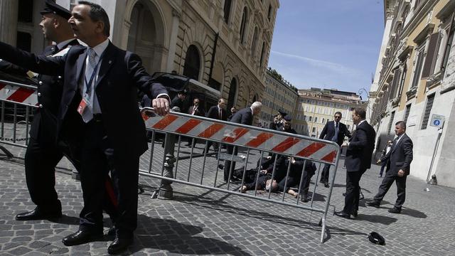 Les premiers secours au chevet d'un des carabiniers blessés devant le siège du gouvernement. [KEYSTONE - AP Photo/Gregorio Borgia]