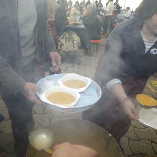 Des bénévoles préparent les assiettes de soupe pour les personnes défavorisées. [Salvatore Di Nolfi]