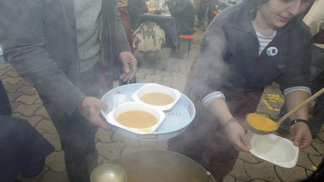 Des bénévoles préparent les assiettes de soupe pour les personnes défavorisées. [Salvatore Di Nolfi]