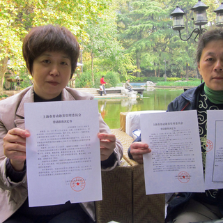 Cui Fu Fang et Shen Yong Mei présentent le certificat attestant de leur passage dans les camps de rééducation chinois. [Raphaël Grand]