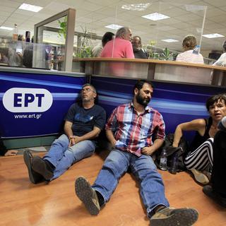 Des employés de la télévision publique grecque ERT après l'annonce de l'arrêt de la diffusion des émissions. [EPA / Keystone - Simela Pantzartzi]