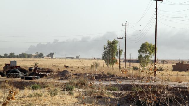 De la fumée se dégage durant des combats entre les forces de sécurité irakiennes, soutenues par des combattants chiites turkmènes, et l'Etat islamique à Amerli, au nord de Bagdad, le 4 août dernier. [ALI AL-BAYATI]