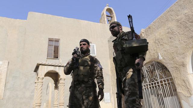 Miliciens chrétiens devant un monstère à Bakufa, près de Mossoul. [AP/Keystone - Bram Janssen]