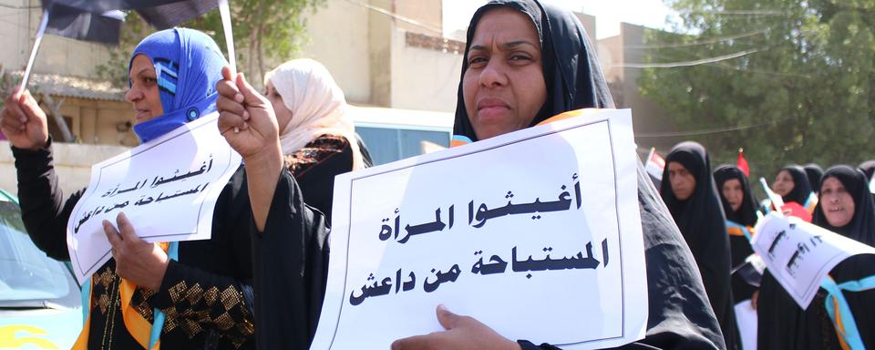 Ces femmes protestent à Bassorah contre les abus commis par les djihadistes de Daesh, comme inscrit sur leurs pancartes. [Mohammed Ali]