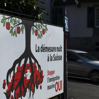 Une affiche de l'UDC sur l'initiative "Contre l'immigration de masse", photographiée à Lausanne en janvier 2014. [Keystone - Jean-Christophe Bott]