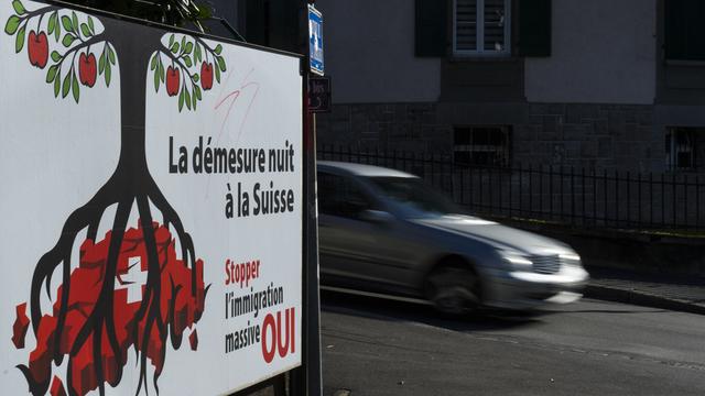 Une affiche de l'UDC sur l'initiative "Contre l'immigration de masse", photographiée à Lausanne en janvier 2014. [Keystone - Jean-Christophe Bott]