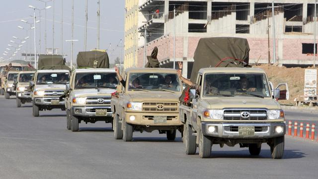 Un convoi de combattants peshmergas kurdes quittant mardi la ville d'Erbil en Irak, pour la ville syrienne de Kobané. [Azad Lashkari]