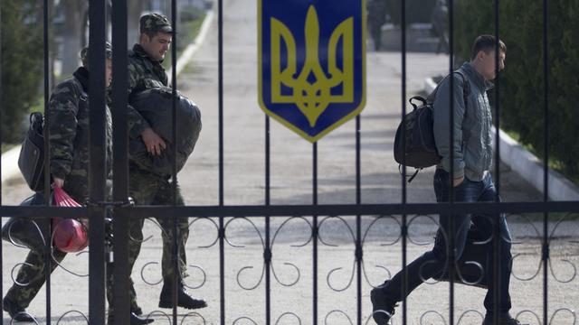 Des soldats de l'armée ukrainienne quitte la base aérienne de Belbek, près de Sebastopol. [AP Photo - Ivan Sekretarev]