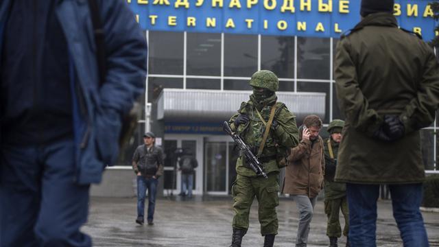 Des hommes armés patrouillent devant l'aéroport de Simferopol en Crimée. [AP Photo - Andrew Lubimov]