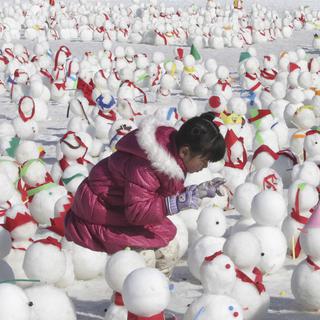 Dimanche 26 janvier: un enfant au milieu des bonhommes de neige durant le Festival de glace de Hwacheon, en Corée du Sud. [AP Photo/Ahn Young-joon]