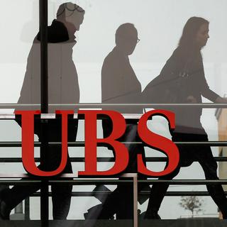 7 février 2012 - Des employés marchent dernière le logo de la banque UBS à Zurich. [Reuters - Arnd Wiegmann]