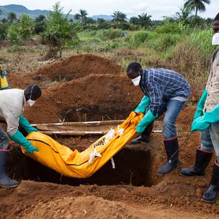 Des volontaires, en habits de protection, enterrent une victime d'Ebola, le 7 octobre 2014 à Waterloo en Sierra Leone. [Florian Plaucheur]
