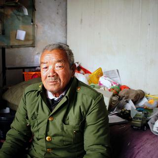 Cet homme vit dans les décombres d'une ancienne usine. Il n'a jamais vu Pékin, mais se dit heureux des avancées économiques de son pays. [Raphaël Grand]