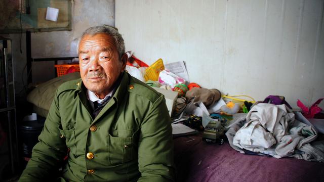 Cet homme vit dans les décombres d'une ancienne usine. Il n'a jamais vu Pékin, mais se dit heureux des avancées économiques de son pays. [Raphaël Grand]