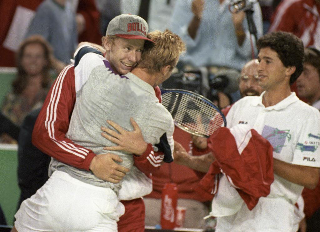 Marc Rosset, links, und Claudio Mezzadri, rechts, umarmen und bejubeln am 25. September 1992 in Genf Jakob Hlasek, Mitte, nach seinem Sieg in einem Einzel-Spiel im Davis Cup Halbfinal der Schweiz gegen Brasilien. Die Schweiz gewinnt den Davis Cup Halbfinal gegen Brasilien und qualifiziert sich fuer den Davis Cup Final. (KEYSTONE/Patrick Aviolat) [KEYSTONE - Patrick Aviolat]