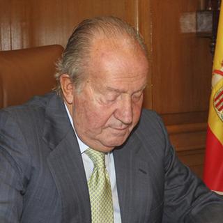 Juan Carlos signe les papiers concernant son abdication [AP Photo/Spanish Royal Palace]