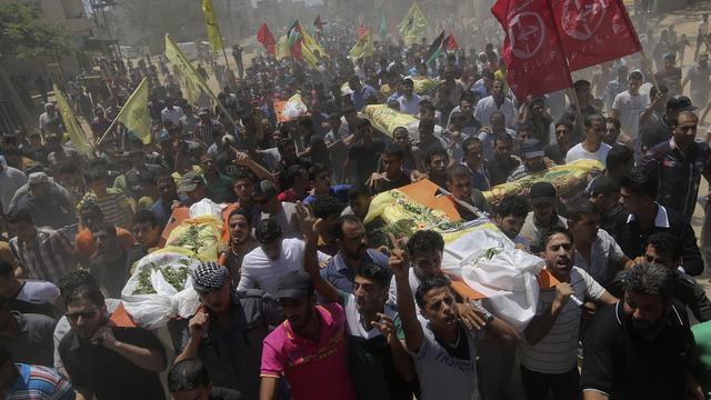 Des Palestiniens portent les corps de sept personnes tuées lors des raids. [AP Photo/Hatem Moussa]