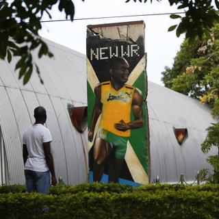 A visitor looks at a section of the Berlin Wall painted with a mural of Olympic champion Usain Bolt, at the Jamaica Military Museum and Library at Up Park Camp, headquarters of the Jamaica Defense Force in Kingston, September 13, 2014. The 12-foot section of the wall was given to Bolt in 2009 by the city of Berlin after the runner broke world records in the 100 and 200 meter finals of the World Athletics Championships in that city. REUTERS/ [Gilbert Bellamy]