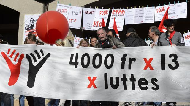 Le cortège lausannois avec des banderoles de soutien à  l'initiative sur le salaire minimum à 4000 francs. [Laurent Gillieron]