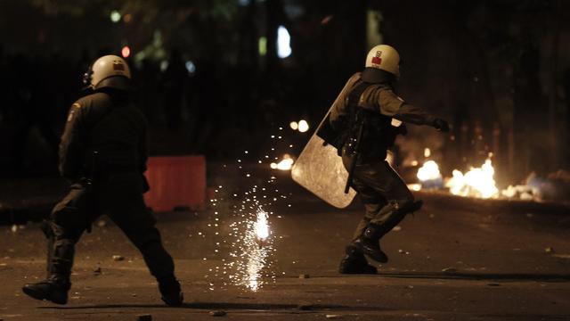 Des policiers anti-émeutes tentent d'éviter des cocktails Molotov lancés par des manifestants, ce samedi 6 décembre 2014 à Athènes. [AP Photo/Petros Giannakouris]