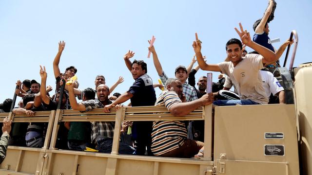 Des hommes irakiens quittent le centre de recrutement pour rejoindre les forces armées à Bagdad, afin d'affronter les bataillons d'insurgés. [AP Photo - Karim Kadim]