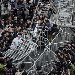 Opération de dématnelement de barricades sous les objectifs des photographes, ce mardi 18 novembre 2014 à Hong Kong. [AFP PHOTO / Philippe Lopez]