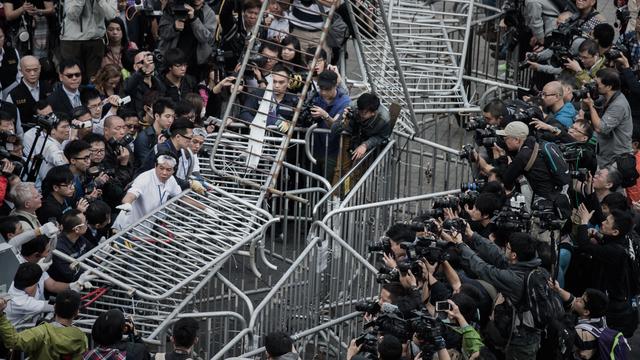 Opération de dématnelement de barricades sous les objectifs des photographes, ce mardi 18 novembre 2014 à Hong Kong. [AFP PHOTO / Philippe Lopez]