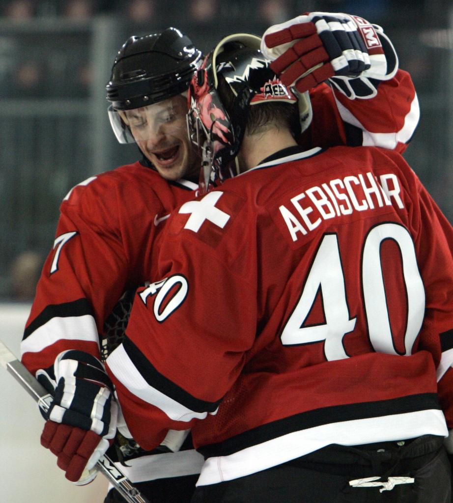 Aebischer (de dos) félicité par Streit après le succès 3-2 contre les Tchèques aux JO de Turin 2006. [KEYSTONE - Eric Risberg]