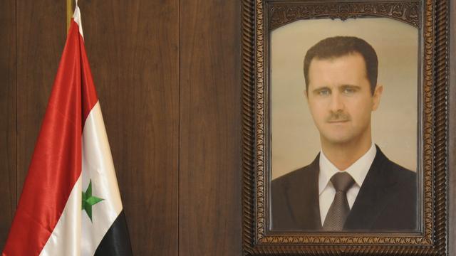 Le président syrien Bachar Al-Assad en portrait (au-dessus du Premier ministre Wael al-Haliqi). [Sana]