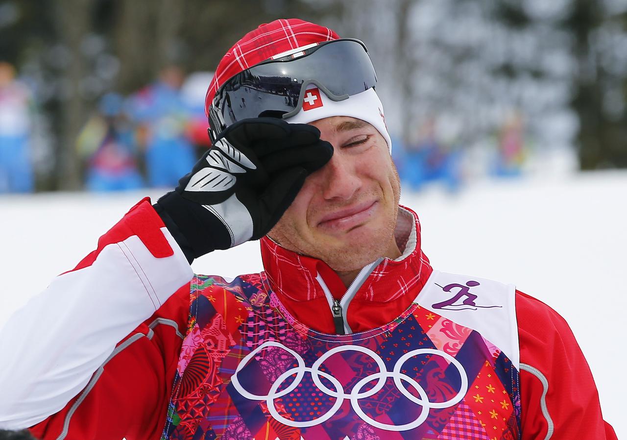 Toute l'émotion de Dario Cologna lors de la cérémonie des fleurs. [Carlos Barria]