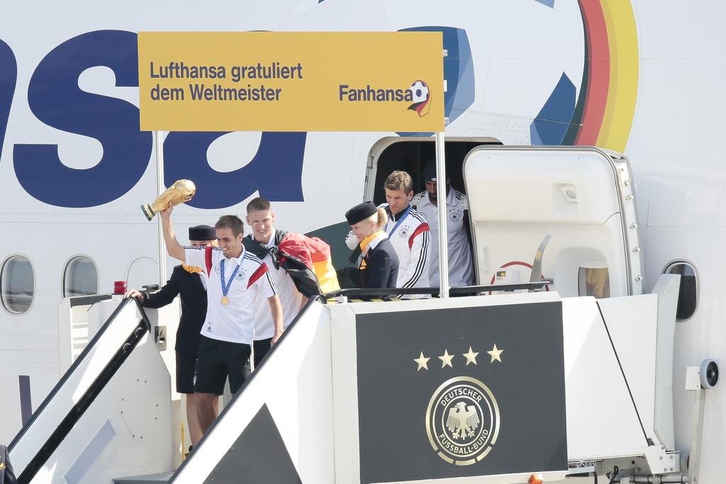 Philipp Lahm, Bastian Schweinsteiger et Cie à la sortie de l'avion. [Keystone - Markus Schreiber]
