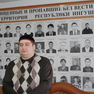Magomed Mutsolgov devant son "mur" de personnes disparues en République d’Ingouchie. [Gaëtan Vannay]