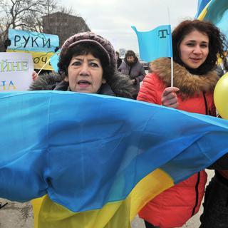 Des femmes brandissent le drapeau ukrainien et tatar de Crimée en scandant "Pas de guerre, nous sommes pour la paix", Simferopol le 8 mars 2014. [Genya Savilov]
