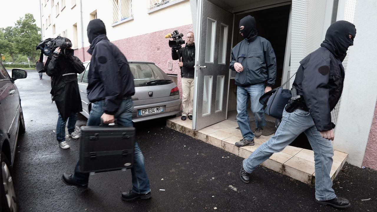 L'équipe du RAID quitte un immeuble de Strasbourg mardi matin avec des documents saisis. [Frederick Florin]