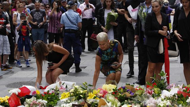Hommage aux victimes de la prise d'otages à proximité des lieux du drame, ce mardi 16 décembre 2014 à Sydney. [AP Photo/Nick Perry)]