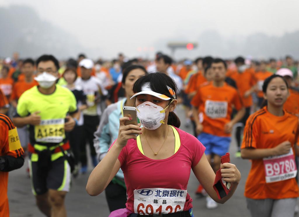 Téléphone portable à la main, cette marathonienne ne manquait pas d'accessoires. [KEYSTONE - Andy Wong]