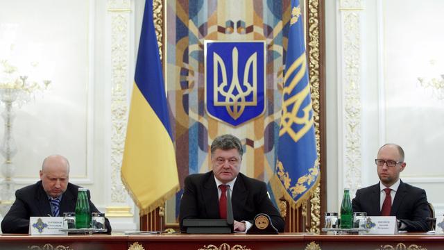 Le président ukrainien, Petro Porochenko, ici avec le Premier ministre Arseny Yatseniuk à droite et le président du Parlement Oleksandr Turchynov à gauche, a réuni en urgence son Conseil national de sécurité et de défense. [Valentyn Ogirenko]